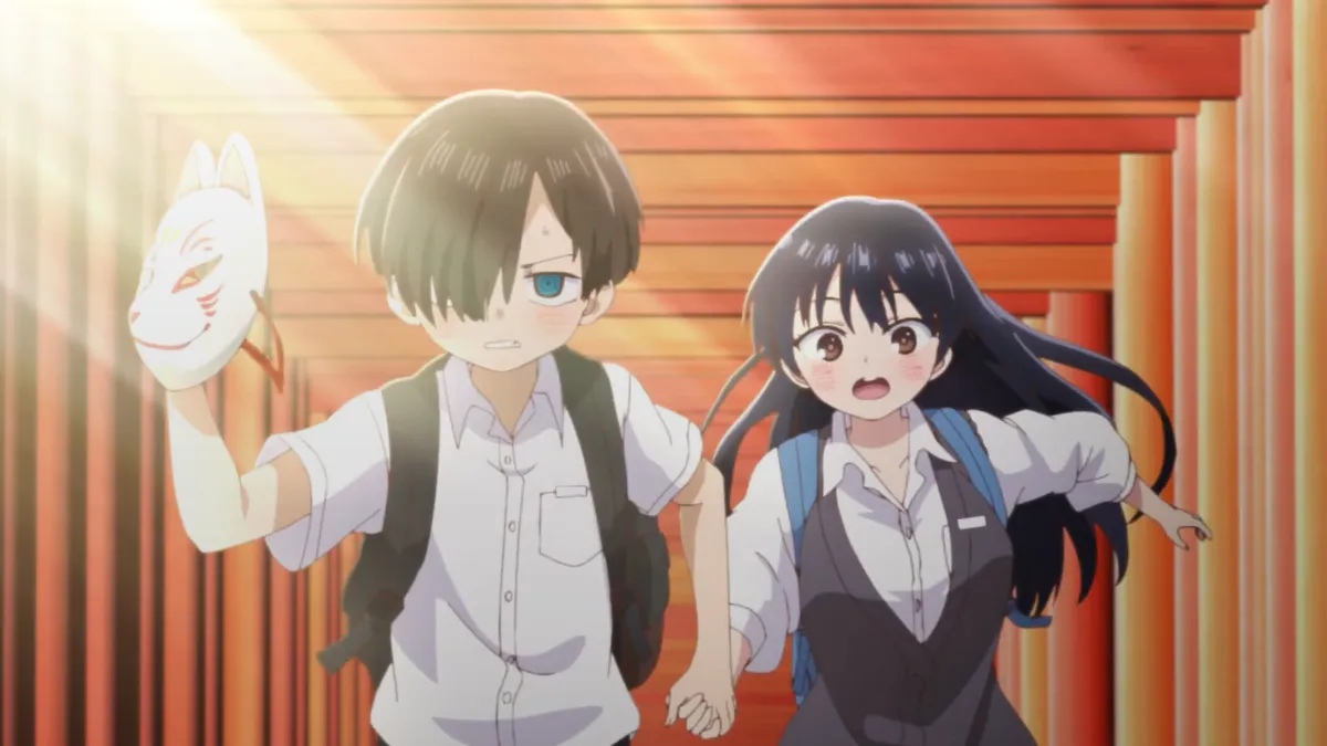A boy holding a fox mask and a girl with long dark hair run hand in hand through a tunnel of red shrine gates, in a still from The Dangers in My Heart: The Movie